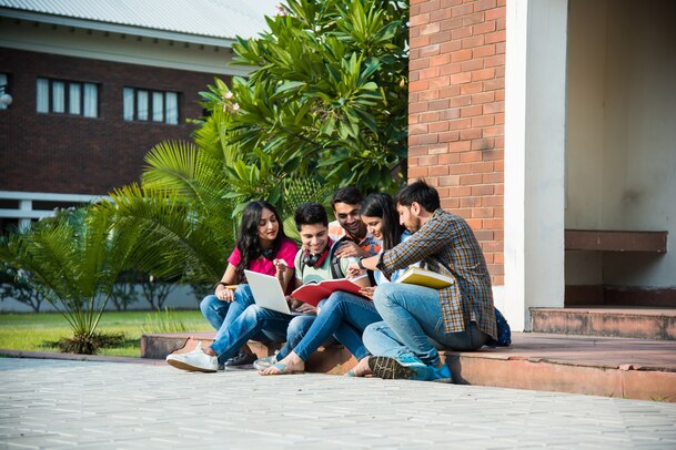 young-asian-indian-college-students-reading-books-studying-laptop-preparing-exam-working-group-project-while-sitting-grass-staircase-steps-college-campus_466689-7728